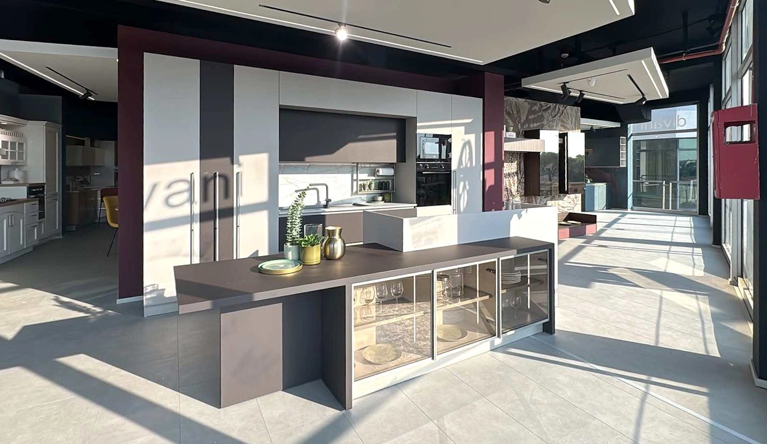 Vista d’insieme dello showroom Turi Cucine Roma, con isola e vetrata
