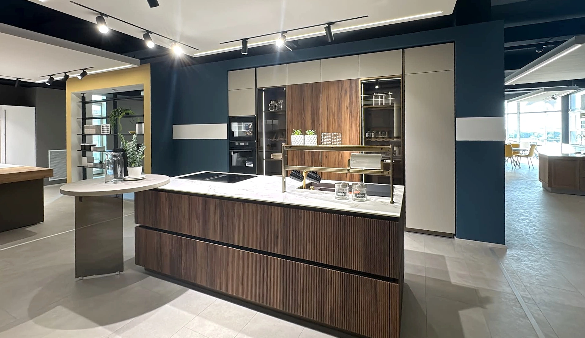 Lo showroom di sera: isola in legno e faretti sul soffitto
