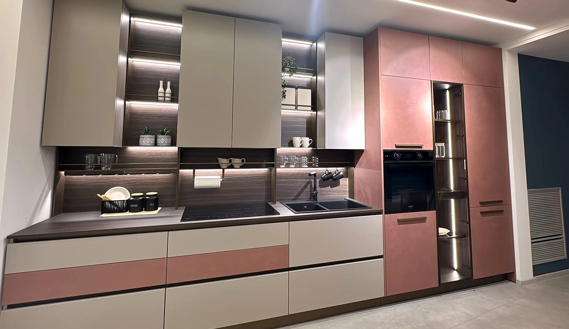 Cucina con ante rosa cipria e illuminazione sottopensile